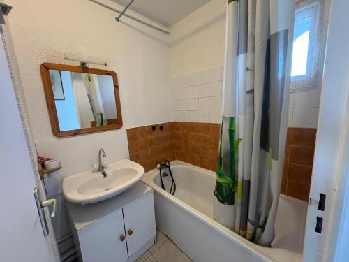 une salle de bain avec un lavabo, une baignoire et un miroir dans l'établissement Studio cabine 4 pers avec piscine à La Grande Motte - FR-1-716-84, à La Grande Motte