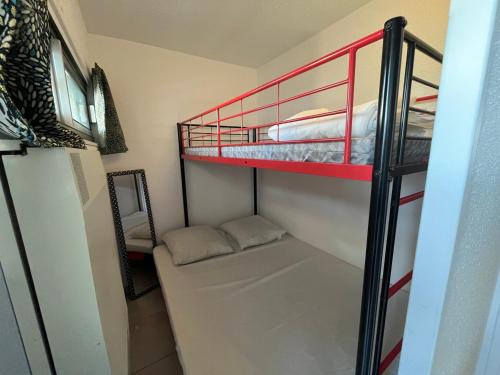Cette petite chambre comprend des lits superposés et un canapé. dans l'établissement Studio cabine 4 pers avec piscine à La Grande Motte - FR-1-716-84, à La Grande Motte