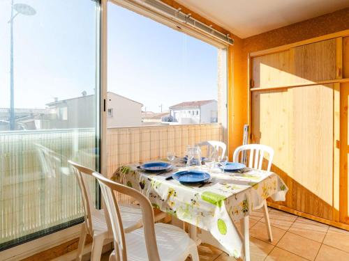 une salle à manger avec une table et des chaises sur un balcon dans l'établissement Appartement T2 avec Wifi, Animaux admis et Parking à Saint-Pierre-La-Mer - FR-1-409-280, à Fleury