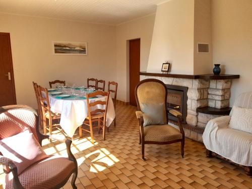 un salon avec une table et des chaises et une cheminée dans l'établissement Maison charmante près de l'océan à Lit-et-Mixe - FR-1-50-170, à Lit-et-Mixe