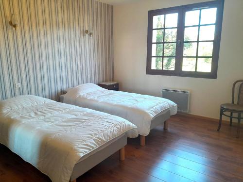 two beds in a room with a window at Maison charmante près de l'océan à Lit-et-Mixe - FR-1-50-170 in Lit-et-Mixe