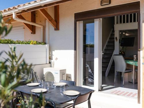 - une table avec des verres sur la terrasse dans l'établissement Villa T2 avec mezzanine, Wi-Fi, climatisation, animaux admis, parking, pour 4 personnes - FR-1-409A-34, à Gruissan