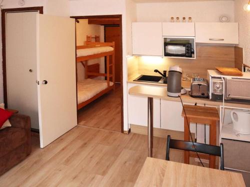 une petite cuisine avec une table et une chambre avec un lit dans l'établissement Studio calme à 20 m des pistes - FR-1-322-666, aux Orres