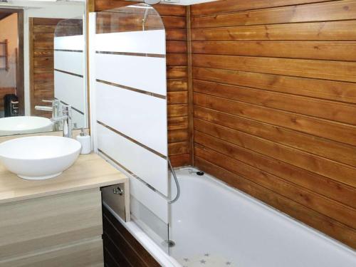 La salle de bains est pourvue d'un lavabo blanc et d'un mur en bois. dans l'établissement Studio calme à 20 m des pistes - FR-1-322-666, aux Orres