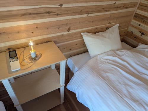 a bedroom with a bed and a table with a lamp at Riviera Iya Valley in Akano