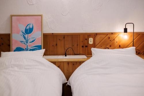 two white beds in a bedroom with a mirror at Coast Villa DAISEN in Daisen