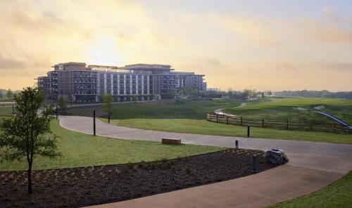 a rendering of a building with a park and a road at Omni PGA Frisco Resort by Suiteness in Frisco