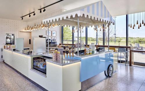 a restaurant with a counter with a bar with drinks at Omni PGA Frisco Resort by Suiteness in Frisco