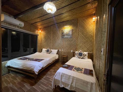 a bedroom with two beds and a chandelier at Quế Homestay in Hòa Bình
