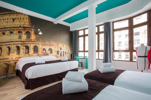 a hotel room with two beds and a mural of the coliseum at Casual Vintage Valencia in Valencia