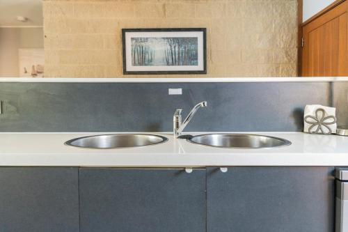 a kitchen counter with two sinks in a kitchen at Reflections on the lake with resort access in Twin Waters