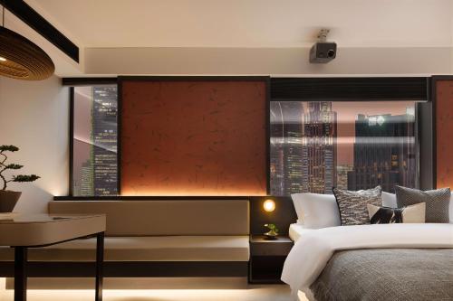 a bedroom with a bed and a view of a city at 成都s恩季酒店春熙路太古里店 in Chengdu