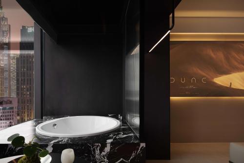 a bathroom with a white tub on a black wall at 成都s恩季酒店春熙路太古里店 in Chengdu
