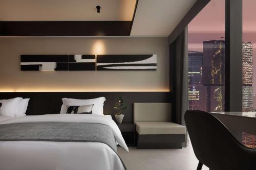 a bedroom with a bed and a view of a city at 成都s恩季酒店春熙路太古里店 in Chengdu