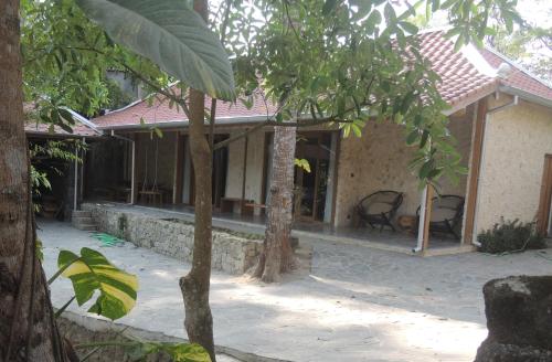 a house with two chairs in front of it at Imalee - Cottage in Yogyakarta