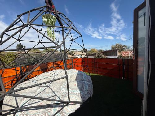 a metal tower with a plant in it next to a building at Beehouse TinyGreen Jacuzzi Opcional in Villa Alemana