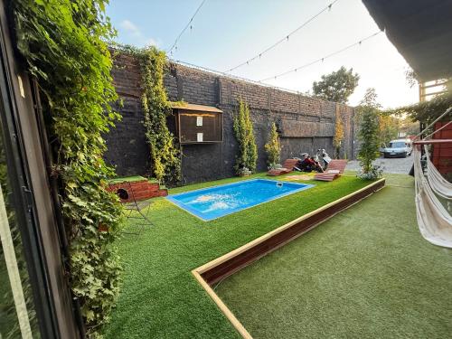 a backyard with a swimming pool and green grass at Beehouse TinyGreen Jacuzzi Opcional in Villa Alemana