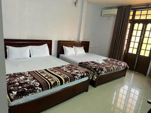 Dos camas una al lado de la otra en un dormitorio. en Nhà nghỉ THANH HẰNG, en Hue