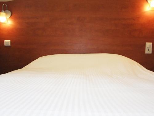a white bed in a bedroom with two lights at Adams Hotel in Metz