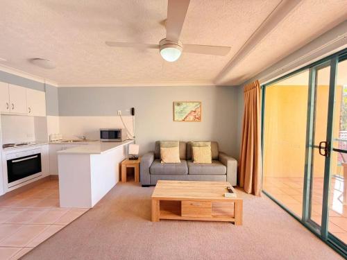 a living room with a couch and a table at Karana Palms Resort in Gold Coast