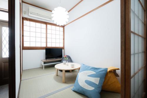 a living room with a couch and a table at LN25三宮徒歩8分の2DKハウスSwallowMaisonet in Kobe