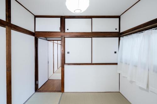 a room with white doors and wooden ceilings at LN25三宮徒歩8分の2DKハウスSwallowMaisonet in Kobe