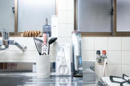 a kitchen counter with a sink with toothbrushes at LN25三宮徒歩8分の2DKハウスSwallowMaisonet in Kobe