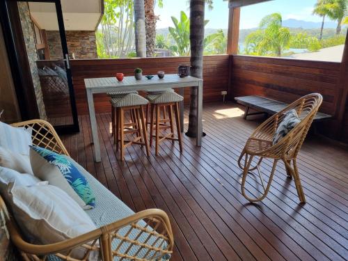 a porch with a table and chairs on a deck at Bermagui Coastal Hideaway - Pet Friendly in Bermagui