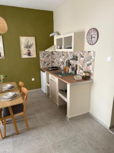 a kitchen with a counter and a table and a clock at Rooms in center of kallithea in Kallithea Halkidikis