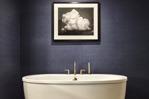 a bathroom with a white tub and a picture of a cloud at Omni PGA Frisco Resort by Suiteness in Frisco