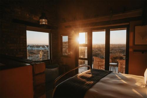 a bedroom with a bed in a room with windows at DagDromer Holiday Home in Jacobs Bay