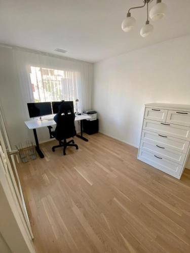 an office with a desk and a computer in a room at Moderne Wohnung mit Einrichtung in Muttenz