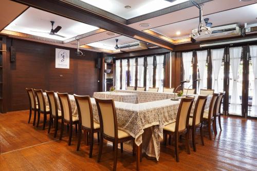 a dining room with a table and chairs at Thanicha Resort Amphawa in Amphawa