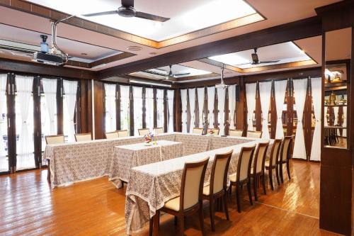 a large dining room with a long table and chairs at Thanicha Resort Amphawa in Amphawa