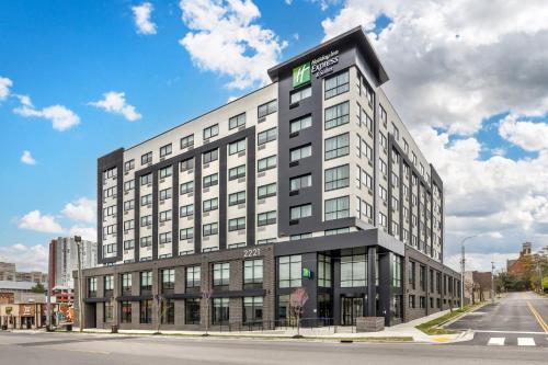 a large white building with a green sign on it at Holiday Inn Express & Suites Nashville West End - Univ Area by IHG in Nashville