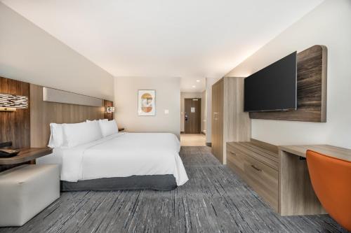 a hotel room with a bed and a flat screen tv at Holiday Inn Express & Suites Nashville West End - Univ Area by IHG in Nashville