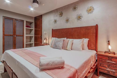 a bedroom with a large bed with a wooden headboard at Sam Nah Luxury House in downtown Mérida in Mérida