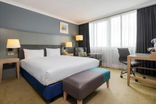 a hotel room with a large bed and a desk at Holiday Inn - Glasgow Airport by IHG in Paisley