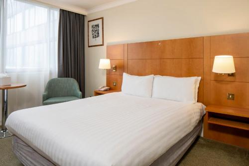 a hotel room with a large bed and a chair at Holiday Inn - Glasgow Airport by IHG in Paisley
