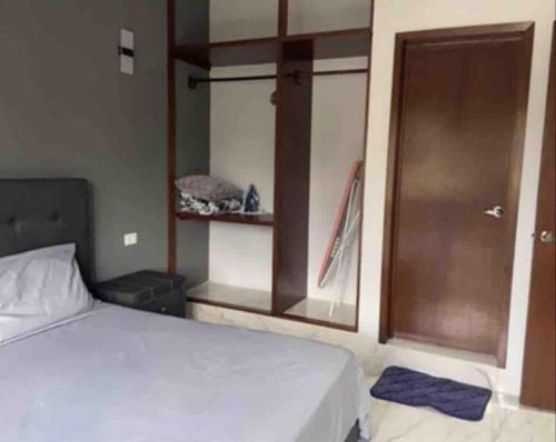 a bedroom with a white bed and a wooden door at Dina's apartment, a charming place with Tina in Valladolid