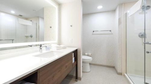 a white bathroom with a sink and a toilet at Holiday Inn Express Hotel & Suites Waterloo - St. Jacobs Area by IHG in Waterloo