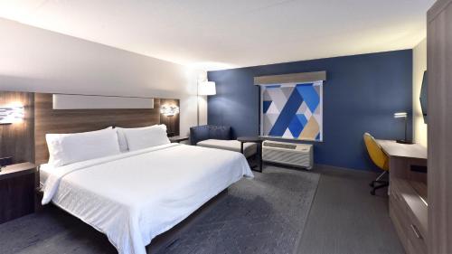 a hotel room with a white bed and a desk at Holiday Inn Express Hotel & Suites Waterloo - St. Jacobs Area by IHG in Waterloo