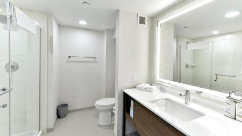 a bathroom with a sink and a toilet and a mirror at Holiday Inn Express Hotel & Suites Waterloo - St. Jacobs Area by IHG in Waterloo
