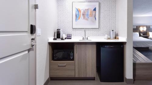 a kitchen with a sink and a bed in a room at Holiday Inn Express Hotel & Suites Waterloo - St. Jacobs Area by IHG in Waterloo