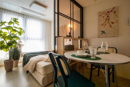 a living room with a table and a bed at 베러댄호텔 제주공항점 in Jeju