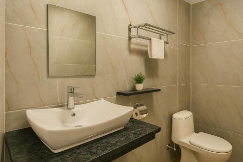 a bathroom with a white sink and a toilet at The Whispering Pines by Trekocity in Lachung