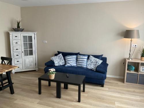 a living room with a blue couch and a table at Fisherman's House by Hofstad Hotels in Scheveningen