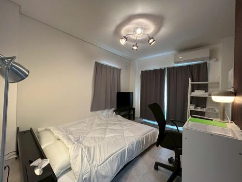 a bedroom with a bed and a desk with a computer at SABBATH uzumaza 103 in Kyoto