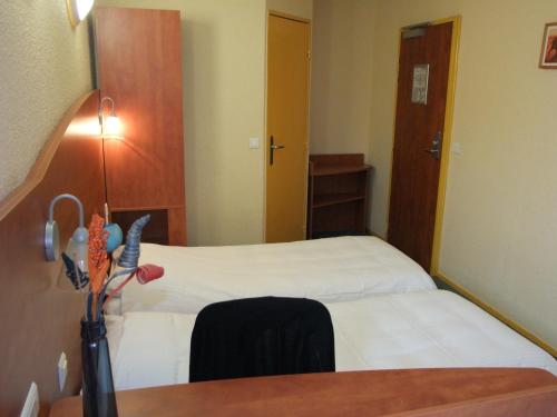 a bedroom with two beds and a table with a mirror at Adams Hotel in Metz
