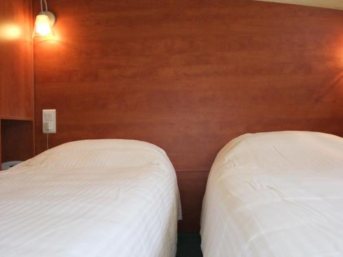 two beds in a room with wooden walls at Adams Hotel in Metz